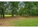 Large backyard with mature trees, a flat grassy area and lots of space at 1267 Austin Bridge Rd, Douglasville, GA 30134