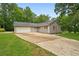 Exterior view of home featuring metal roof, garage, driveway, and well-manicured lawn at 1267 Austin Bridge Rd, Douglasville, GA 30134
