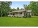 Inviting single-story home with a charming front porch and well-manicured lawn at 1267 Austin Bridge Rd, Douglasville, GA 30134