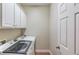 Bright laundry room with white cabinets, machines, and tile flooring at 1283 Silver Trace Sw Dr, Lilburn, GA 30047