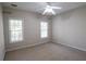Well-lit carpeted bedroom featuring a ceiling fan and two windows offering natural light at 19 Thimblemill Ct, Villa Rica, GA 30180
