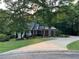 Traditional brick home features a white porch, manicured lawn, and a winding driveway at 19 Thimblemill Ct, Villa Rica, GA 30180