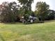 Brick house with white trim is surrounded by mature trees and green lawn at 19 Thimblemill Ct, Villa Rica, GA 30180