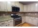 Bright kitchen with stainless steel appliances, light cabinets, granite counters, gas range, and tile backsplash at 19 Thimblemill Ct, Villa Rica, GA 30180