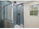 Sleek walk-in shower with blue tiled walls, glass doors and a window for natural light at 35 Lady Morgan Ln, Dallas, GA 30157