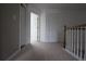 Upstairs hallway with neutral carpet, wooden railing and white doors at 838 Roxholly Ln, Buford, GA 30518