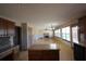 The kitchen has an island, wooden cabinets, and stainless steel appliances opening up into the spacious living room at 838 Roxholly Ln, Buford, GA 30518