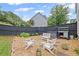 Private backyard with a stone seating area, black fence, and mature landscaping at 121 Bradshaw Park Dr, Woodstock, GA 30188