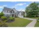 Landscaped front yard featuring a well-manicured lawn, vibrant flowers, and a charming two-story home with a covered front porch at 121 Bradshaw Park Dr, Woodstock, GA 30188