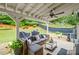 Relaxing covered patio features ceiling fan, wicker furniture set, and outdoor dining area at 121 Bradshaw Park Dr, Woodstock, GA 30188