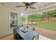 Covered patio with stone flooring offers a dining table with seating and view of the yard at 121 Bradshaw Park Dr, Woodstock, GA 30188