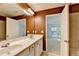 A bathroom with double vanity with a large mirror and white cabinets, plus an adjoined toilet area and bedroom at 2008 Hailston Dr, Duluth, GA 30097