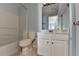 A bathroom with a tub and vanity with white cabinets and a large mirror with natural lighting from the window at 2008 Hailston Dr, Duluth, GA 30097