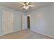 A carpeted bedroom with light blue walls featuring a ceiling fan and white doors at 2008 Hailston Dr, Duluth, GA 30097