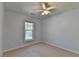 A bright bedroom with a ceiling fan has a window letting in natural light with neutral colored carpet at 2008 Hailston Dr, Duluth, GA 30097