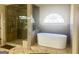 Contemporary bathroom with soaking tub and glass shower; half moon window above tub at 6205 Arnall Nw Ct, Acworth, GA 30101