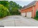 Expansive driveway leading to a three-car garage, set against a backdrop of lush greenery at 6205 Arnall Nw Ct, Acworth, GA 30101