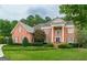 Stately brick home featuring a meticulously landscaped front yard and classic architectural details at 6205 Arnall Nw Ct, Acworth, GA 30101
