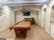Finished basement with exposed brick walls, statement lighting, a pool table, and bar area at 6205 Arnall Nw Ct, Acworth, GA 30101