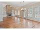 Bright living room featuring stone fireplace, hardwood flooring, plantation shutters, and built-in shelving at 6205 Arnall Nw Ct, Acworth, GA 30101