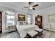Comfortable bedroom features stylish decor, plush bedding, ceiling fan, and natural light at 1002 Harvest Park Ln, Suwanee, GA 30024