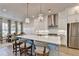 A modern kitchen features an island with seating, stainless steel appliances, and an open-concept design at 1002 Harvest Park Ln, Suwanee, GA 30024