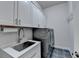 Laundry room featuring front loading washer and dryer, a utility sink and custom cabinetry at 1002 Harvest Park Ln, Suwanee, GA 30024