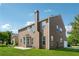 Backyard view of a two-story home with a chimney, patio, and expansive grassy area at 3134 Flery Way, Lawrenceville, GA 30046
