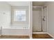Bathroom featuring a soaking tub with tile surround and a separate glass enclosed shower at 3134 Flery Way, Lawrenceville, GA 30046
