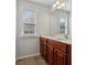 Bathroom featuring double sinks with cherry wood cabinets, a large mirror, and a window at 3134 Flery Way, Lawrenceville, GA 30046