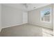 Empty bedroom with neutral carpet, a ceiling fan, a large window, and fresh paint at 3134 Flery Way, Lawrenceville, GA 30046