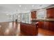 Open-concept kitchen boasts a center island, wood floors, granite countertops, and seamlessly connects to the living area at 3134 Flery Way, Lawrenceville, GA 30046