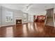 Open concept design featuring hardwood floors, a fireplace, and a view of the kitchen and staircase at 3134 Flery Way, Lawrenceville, GA 30046