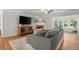 Relaxing living room featuring a brick fireplace, hardwood floors, large windows, and a comfortable gray sofa at 4371 N Park Dr, Tucker, GA 30084