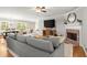 Inviting living room with a fireplace, hardwood floors, large windows, and a comfortable gray sofa at 4371 N Park Dr, Tucker, GA 30084