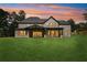Exterior shot of the back of a large modern two-story home with a covered patio overlooking the yard at 4539 Braselton Hwy, Hoschton, GA 30548