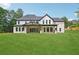 Backyard view of elegant home showcasing a covered patio and manicured lawn at 4539 Braselton Hwy, Hoschton, GA 30548
