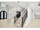 Bright foyer featuring hardwood floors, staircase with black railing, and decorative front door at 4539 Braselton Hwy, Hoschton, GA 30548