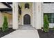 Arched wrought iron double front door flanked by modern outdoor lighting at 4539 Braselton Hwy, Hoschton, GA 30548