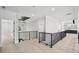 Second floor hallway with modern railing, light wood floors, and access to multiple rooms with ample lighting at 4539 Braselton Hwy, Hoschton, GA 30548