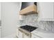 Close-up of a high-end range with custom hood and marble backsplash at 4539 Braselton Hwy, Hoschton, GA 30548