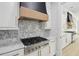 Stylish kitchen features a chef-quality range, custom hood, and marble backsplash at 4539 Braselton Hwy, Hoschton, GA 30548