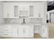 Custom built-in wet bar featuring white cabinets, marble countertops and backsplash at 4539 Braselton Hwy, Hoschton, GA 30548