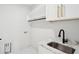 Bright laundry room with marble countertops, stainless steel sink, and white cabinetry for storage and organization at 4539 Braselton Hwy, Hoschton, GA 30548