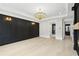 Spacious living room with fireplace, hardwood floors, and elegant chandelier provides a sophisticated ambiance at 4539 Braselton Hwy, Hoschton, GA 30548