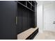 Mudroom boasts custom black cabinets with gold hardware and a built-in bench for storage at 4539 Braselton Hwy, Hoschton, GA 30548
