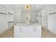 Bright walk-in closet with custom shelving, center island, and elegant light fixture at 4539 Braselton Hwy, Hoschton, GA 30548