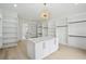 Open walk-in closet with custom shelving, central island, and designer light fixture at 4539 Braselton Hwy, Hoschton, GA 30548