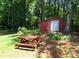 Backyard with a classic picnic table and shed, offering an outdoor space for dining and storage at 5152 Suggs St, Powder Springs, GA 30127