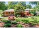 Large backyard with a picnic table, a small patio, and lush landscaping surrounding the house at 5152 Suggs St, Powder Springs, GA 30127